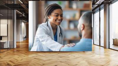 Cheerful african american woman doctor touching male patient shoulder Wall mural