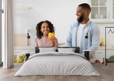 Cheerful african father and daughter cooking healthy salad Wall mural