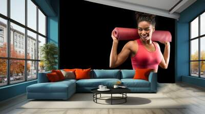 Cheerful black girl in sportswear holding yoga mat Wall mural