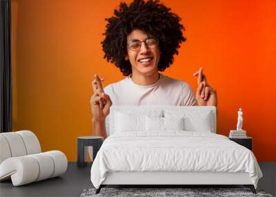 Cheerful black guy crossing fingers for luck Wall mural