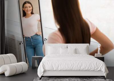 Cheerful Fit Woman Looking At Reflection In Mirror Standing Indoor Wall mural