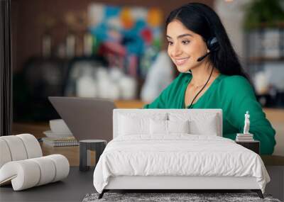 Cheerful indian woman having video call with colleagues, cafe interior Wall mural