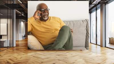 Cheerful Mature Black Man Chatting On Cellphone Sitting At Home Wall mural