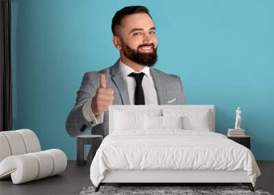 Cheerful millennial businessman showing thumb up gesture on blue background Wall mural