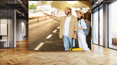 Cheerful millennial european family tourists with suitcase stop taxi, wait transport on station Wall mural