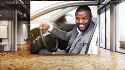 Cheerful successful black businessman looking through car window Wall mural