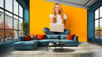 cheerful woman using laptop and showing thumb up Wall mural