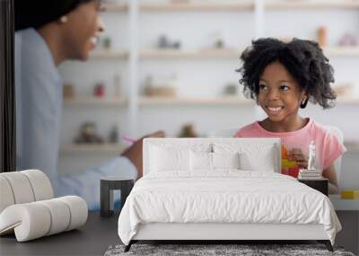 Child development specialist having session with cheerful little girl Wall mural