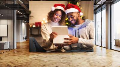 Christmas magic. Afro couple opening gift box Wall mural