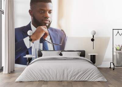 Close up of man in suit reading reports on laptop Wall mural