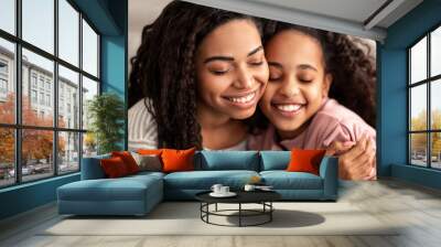 Close up portrait of black mother and daughter hugging Wall mural