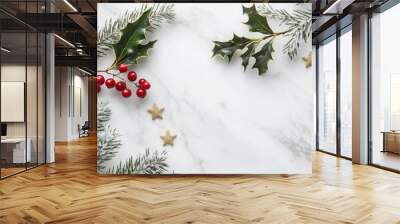 Closeup of a white marble surface with sprigs of holly and pine. The holly has bright red berries and the pine is dusted with snow. There are also three gold stars scattered around the arrangement. Wall mural