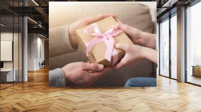 closeup of father hands gives gift to daughter Wall mural