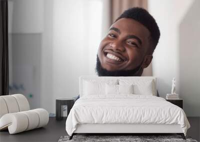 Closeup portrait of cheerful african american guy indoors Wall mural