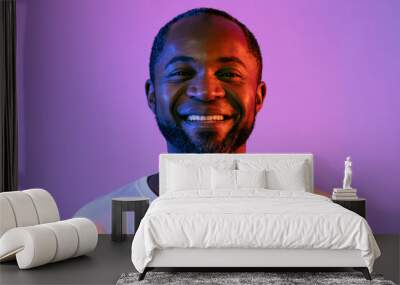 Closeup portrait of handsome black man on neon background Wall mural