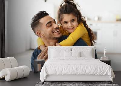 Closeup portrait of happy middle-eastern father and little daughter embracing at home Wall mural