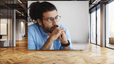 Closeup Portrait Of Pensive Millennial Indian Man In Eyeglasses Looking Away Wall mural