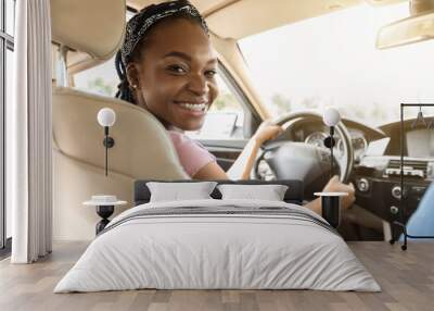 Confident black woman driving car, smiling at camera Wall mural