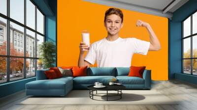 Confident strong teenager enjoying milk and showing his biceps Wall mural