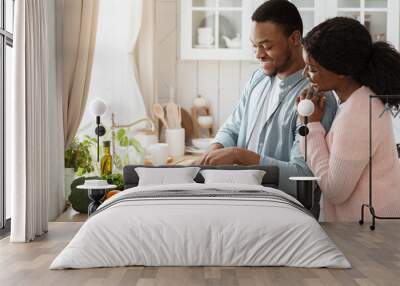 Cooking Together. Portrait of happy affectionate black couple preparing lunch in kitchen Wall mural