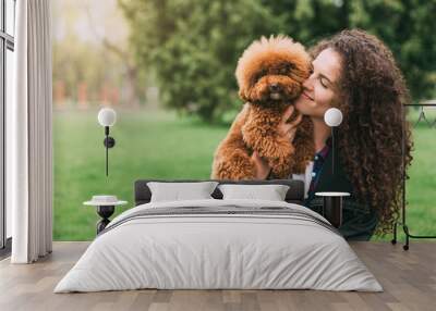 Cool puppy and young woman having fun in park Wall mural