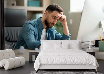 Creativity Crisis. Stressed businessman sitting at desk in office and crumpling paper Wall mural