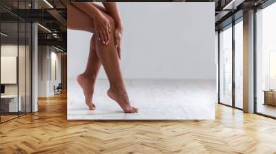 Cropped of female legs, woman touching her skin after waxing Wall mural