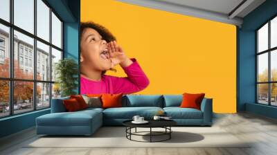 Cute little african american girl shouting at copy space, making announcement Wall mural