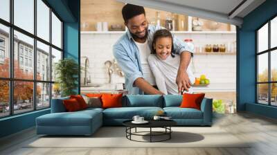 Cute little girl enjoying cooking dinner with lovely daddy Wall mural