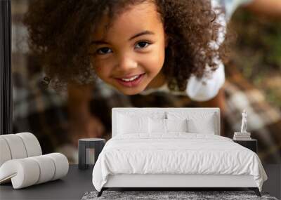 Cute little girl playing on blanket and looking up Wall mural