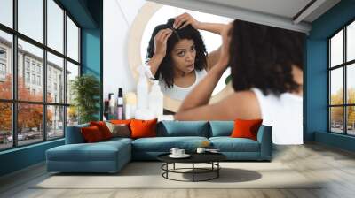 Dandruff Problem. Sad Black Woman Looking At Her Hair Roots In Mirror Wall mural