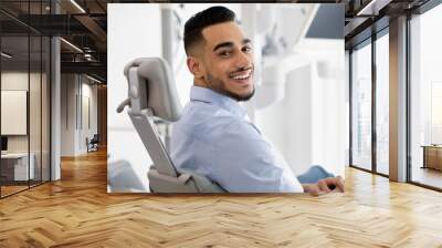 Dental Clinic Patient. Portrait Of Smiling Arab Male Posing In Dentist Chair Wall mural