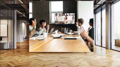 Diverse businesspeople making online video call to employees Wall mural