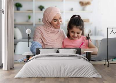 Doing Homework Together. Loving Muslim Mom Helping Her Little Daughter With Study Wall mural