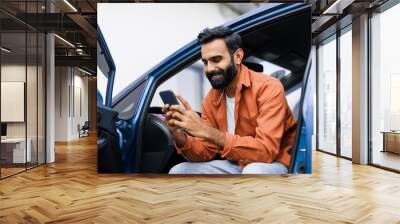 Eastern Man Using Phone Sitting In Auto With Opened Door Wall mural