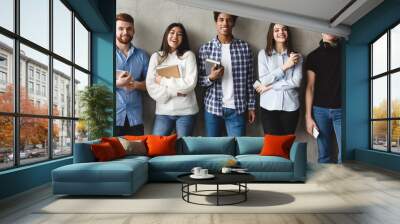 Education concept. Students smiling to camera over grey wall Wall mural