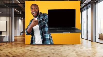 Emotional African American Guy Showing Laptop Screen Over Yellow Background Wall mural