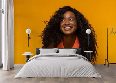 Excited african woman with wide smile looking aside Wall mural