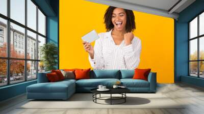 Excited afro woman holding phone celebrating success Wall mural