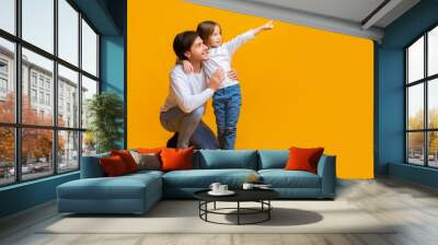 Excited little girl showing her daddy amazing advertisement Wall mural