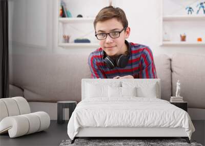 Excited teenage boy playing video game at home Wall mural