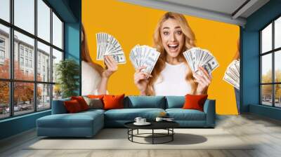 Excited young girls holding bunch of dollars and screaming Wall mural