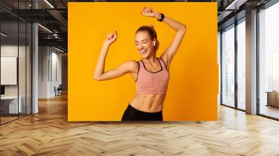 Excited Young Lady In Sportswear Dancing On Yellow Background Wall mural