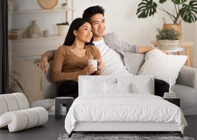 Filipino couple resting at home and watching tv Wall mural