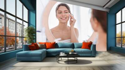 Fresh looking girl using cotton pad, cleamsing morning procedures Wall mural