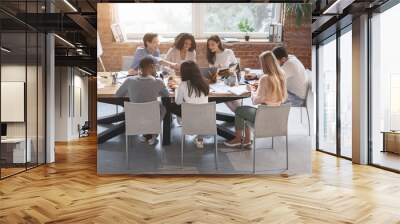 Friendly business team sitting around table, having meeting Wall mural