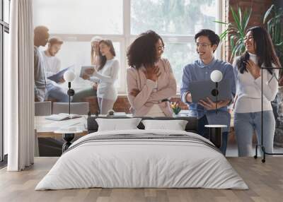 Friendly multiracial colleagues having conversation in office Wall mural