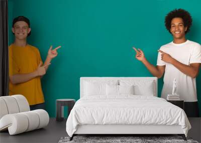 Friendly teen boys pointing on copy space Wall mural