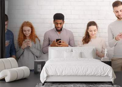 Gadget addiction. Group of students with smartphones Wall mural