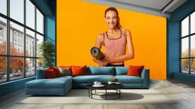 Girl Holding Fitness Mat Looking At Camera Standing, Studio Shot Wall mural